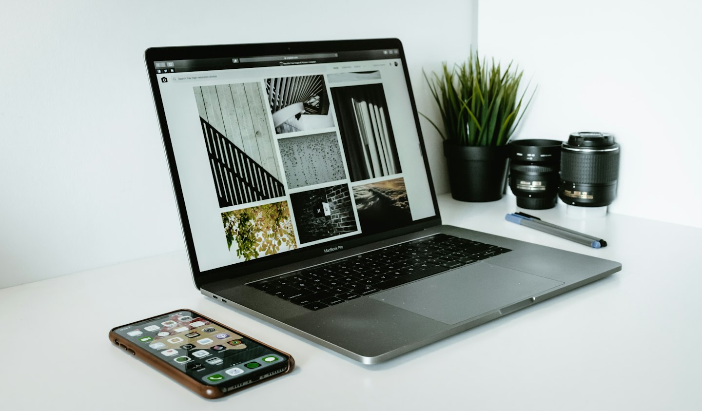 Laptop on white desk showing photo gallery website.